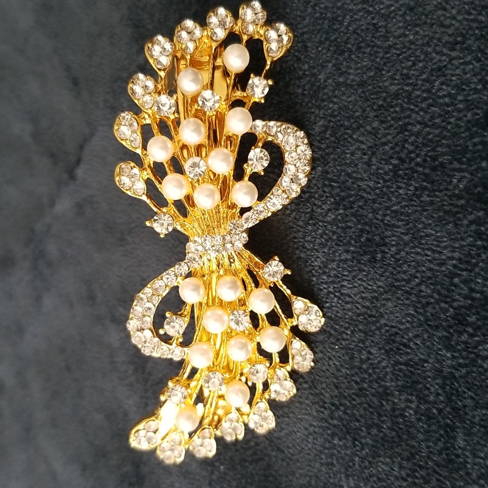 Hair accessory in gold color with crystals and pearls.